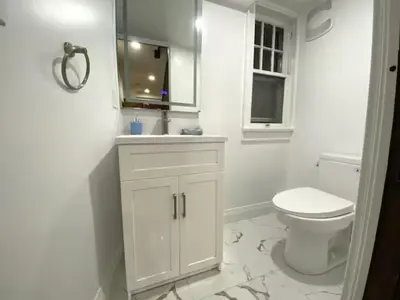 a white bathroom with a toilet and a sink at Classic Home in Niagara Falls