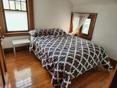 a bedroom with a bed with a black and white comforter at Classic Home in Niagara Falls