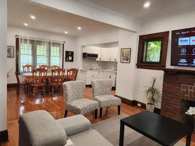 a living room with a table and chairs and a kitchen at Classic Home in Niagara Falls