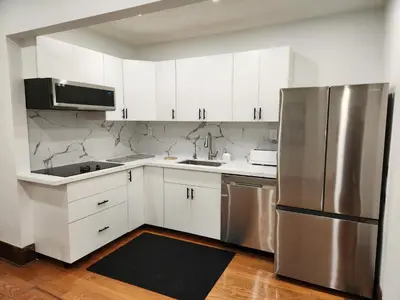 a kitchen with white cabinets and a stainless steel refrigerator at Classic Home in Niagara Falls