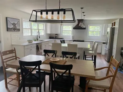 a kitchen with a table and chairs and a dining room at Centre Gate House Licence# 117-2023 in Niagara on the Lake
