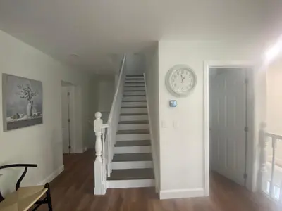 a stairway with a clock on a wall at Centre Gate House Licence# 117-2023 in Niagara on the Lake