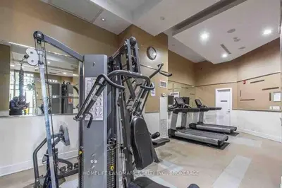 a gym with treadmills and machines in a room at City Centre Lodge ( Downtown) in Mississauga