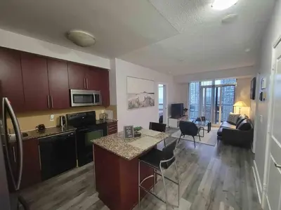 a kitchen and living room with a table and a counter at City Centre Lodge ( Downtown) in Mississauga
