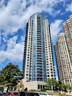 a tall building with cars parked in front of it at City Centre Lodge ( Downtown) in Mississauga