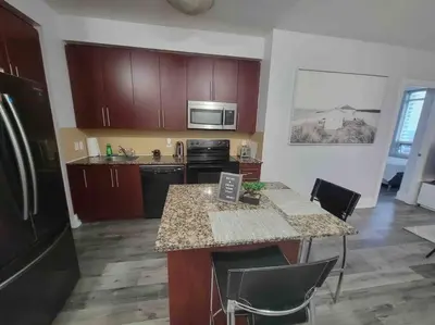 a kitchen with wooden cabinets and a counter top at City Centre Lodge ( Downtown) in Mississauga