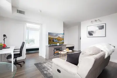 a living room with a white couch and a desk at Luxury 3-Beds Apartment in Yorkville with the Best City View in Downtown Toronto in Toronto