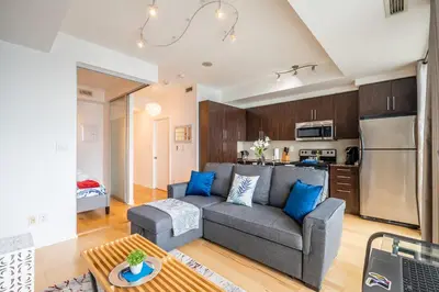 a living room with a couch and a kitchen at 1BR Luxury Condo - Downtown Toronto in Toronto