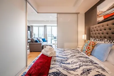 a bedroom with a large bed with a red rug at 1BR Luxury Condo - Downtown Toronto in Toronto