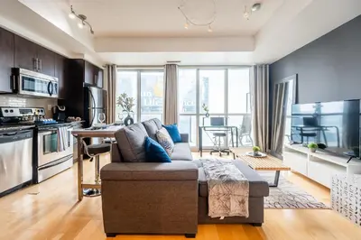 a living room with a couch and a kitchen at 1BR Luxury Condo - Downtown Toronto in Toronto