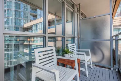 two white chairs and a table on a balcony at Cozy 2BR Close to CN Tower & Harbourfront in Toronto