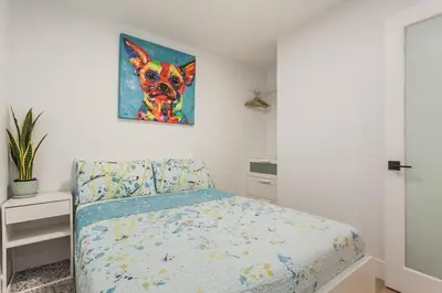 a bedroom with a bed and a painting of a dog at Cozy 2BR Close to CN Tower & Harbourfront in Toronto