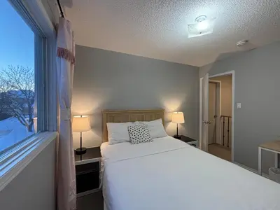 a bedroom with a white bed and a window at Lake Simcoe 4 Bedroom Family Home Ideal Toronto Area Retreat in Innisfil