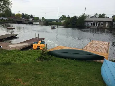 a small boat is parked next to a dock at Balsam Lake Cottage 5 Bed room in Kawartha Lakes