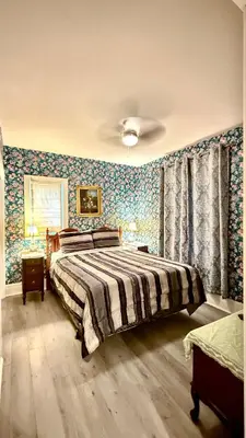a bedroom with a bed with floral wallpaper at Adorable 2-bedroom unit with jacuzzi beside falls in Niagara Falls