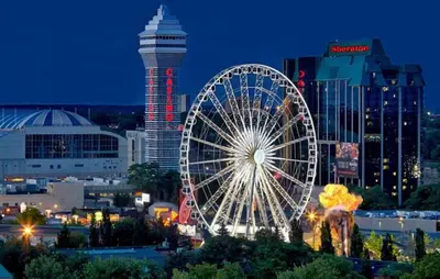 a large ferris wheel in a city at night at Adorable 2-bedroom unit with jacuzzi beside falls in Niagara Falls