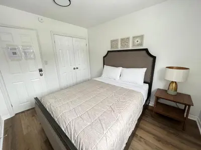 a bedroom with a bed and a lamp and a door at Letitia Heights !C Quiet and Modern Private Bedroom with Shared Bathroom in Barrie