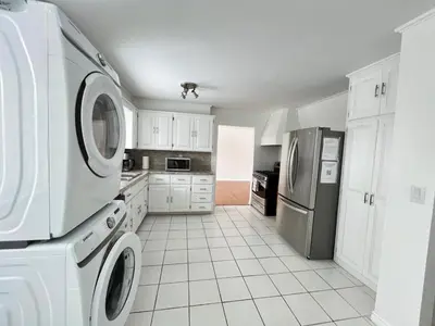 a kitchen with white cabinets and a washer and dryer at Letitia Heights !C Quiet and Modern Private Bedroom with Shared Bathroom in Barrie
