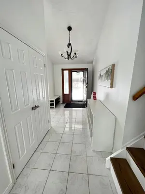 a hallway with a white door and a chandelier at Letitia Heights !D Quiet and Stylish Private Bedroom with Shared Bathroom in Barrie