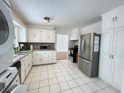 a kitchen with white cabinets and a stainless steel refrigerator at Letitia Heights !D Quiet and Stylish Private Bedroom with Shared Bathroom in Barrie