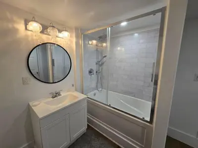 a bathroom with a sink and a shower and a mirror at Private 2-Bedroom Minutes From Trent University in Peterborough