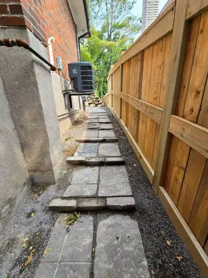 a stone sidewalk next to a fence next to a building at Private 2-Bedroom Minutes From Trent University in Peterborough