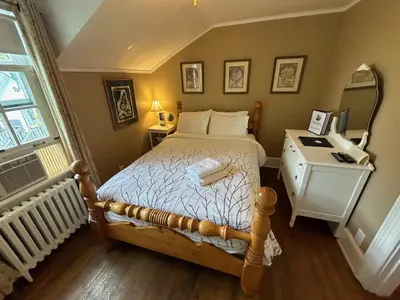 a bedroom with a bed with a dresser and a mirror at Stevenson Farms-Harvest Spa B & B in Alliston