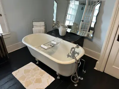 a white bath tub in a bathroom with a mirror at Stevenson Farms-Harvest Spa B & B in Alliston