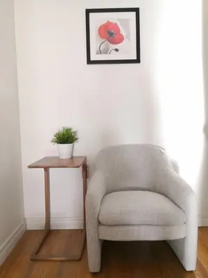 a chair and a side table in a room at spacious and bright house in Toronto