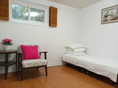 a room with a bed and a chair and a table at spacious and bright house in Toronto