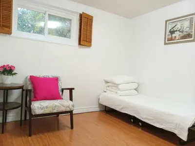 a room with a bed and a chair and a table at spacious and bright house in Toronto