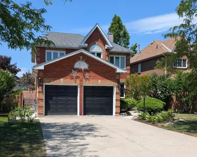 a house with two garage doors in a driveway at Lake-Walk House 3 Bed 2 Bath Apt in Hamilton