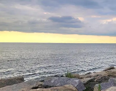 a large body of water with rocks in front of it at Lake-Walk House 3 Bed 2 Bath Apt in Hamilton