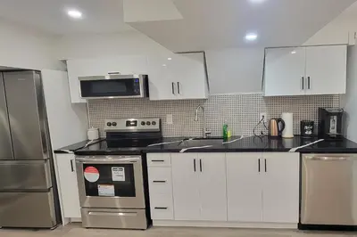 a kitchen with white cabinets and stainless steel appliances at Lake-Walk House 3 Bed 2 Bath Apt in Hamilton