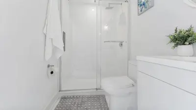a white bathroom with a shower and a toilet at Entire Luxury Suite 4Mins To Falls, Free Parking in Niagara Falls