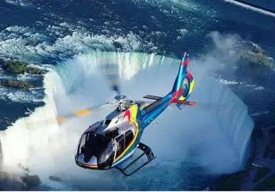 a helicopter flying in front of a waterfall at Entire Luxury Suite 4Mins To Falls, Free Parking in Niagara Falls