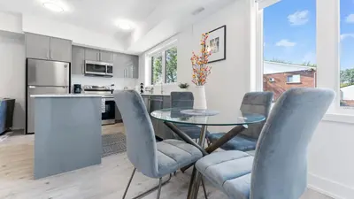 a kitchen and dining room with a glass table and chairs at Entire Luxury Suite 4Mins To Falls, Free Parking in Niagara Falls