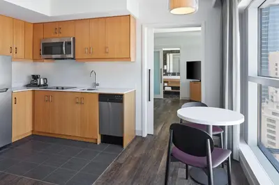 a kitchen with wooden cabinets and a table and chairs at Delta Hotels by Marriott Toronto in Toronto