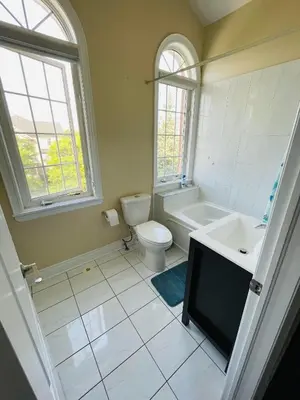 a bathroom with a toilet and a tub and a sink at Jazzy Home Stay in Mississauga