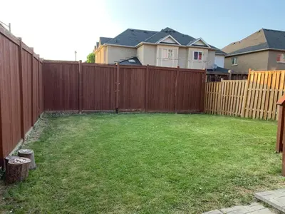 a backyard with a wooden fence and a yard at Jazzy Home Stay in Mississauga