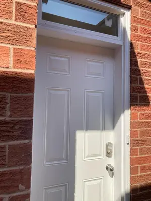 a white door with a window on a brick wall at Brand New, cozy 2 Bdrm Bsmnt Apt in Mississauga
