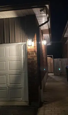 a garage with a white garage door and a brick wall at Brand New, cozy 2 Bdrm Bsmnt Apt in Mississauga