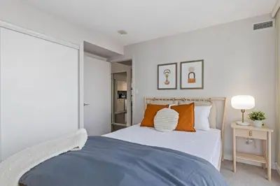 a bedroom with a large bed with orange pillows at Work From home with Parking WIFI and CN Tower View in Toronto