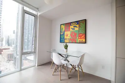 a dining room with a glass table and white chairs at Cozy 1 BR Air mattress CN Tower Ent District MTCC in Toronto