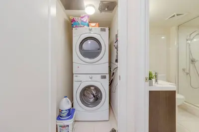 a washer and dryer in a bathroom at LUX 2BR 1BA Steps to CN Tower W Parking included in Toronto