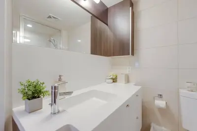 a white bathroom with a sink and a mirror at LUX 2BR 1BA Steps to CN Tower W Parking included in Toronto