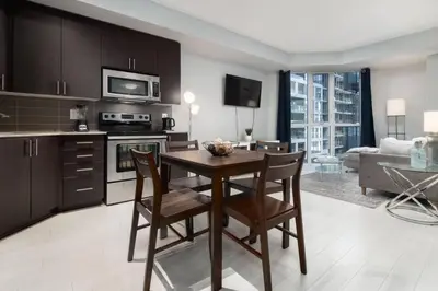 a kitchen and living room with a table and chairs at Modern Condo 1 BD 1BA with a Sofabed Downtown in Toronto