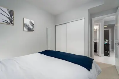 a bedroom with a white bed with a blue pillow at Modern Condo 1 BD 1BA with a Sofabed Downtown in Toronto