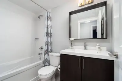 a bathroom with a sink and a toilet and a mirror at Modern Condo 1 BD 1BA with a Sofabed Downtown in Toronto
