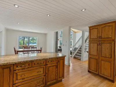 a large kitchen with wooden cabinets and a dining room at Getaway Cottage LAKE FRONT Muskoka Room Kayaks in Dwight